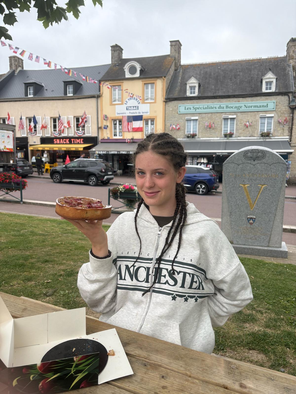 Gloria enjoying a pastry in Normandy